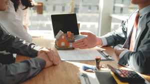 Mortgage broker discussing deal with clients at a table.